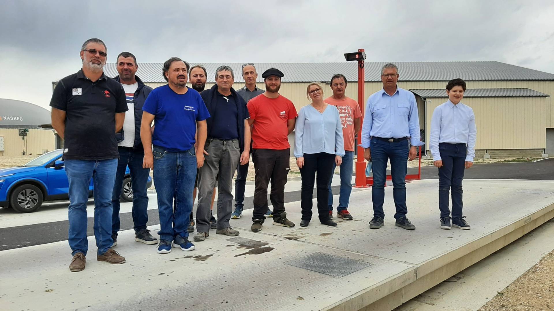 Les fondateurs du projet posent dans un hangar devant une ensileuse